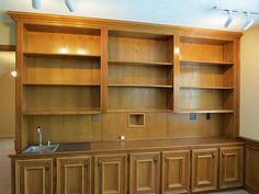 an empty room with wooden cabinets and a sink