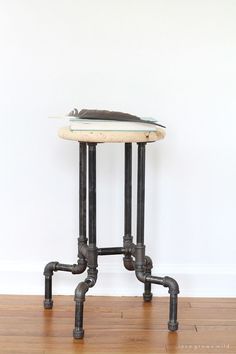 an old pipe table with a book on top and some pipes coming out of it