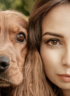 a woman is posing with her dog for the camera