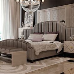 a bedroom with a chandelier hanging from the ceiling and a bed sitting on top of a rug