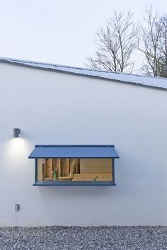 a white building with a blue awning next to it's windows and door