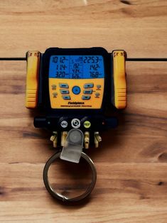 a yellow and black electronic device on top of a wooden table next to a pair of scissors