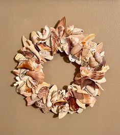 a wreath made out of seashells hangs on the wall