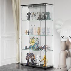 a glass display case filled with lots of toy figurines on top of shelves