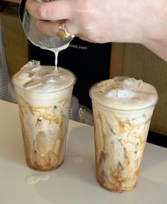 two iced coffee drinks being poured into each other