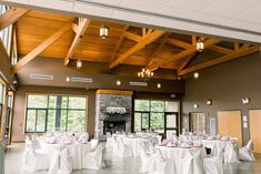 a banquet hall with tables and chairs set up for a formal function in front of large windows