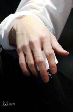 a person wearing a white shirt is holding their hand out to touch something on the table