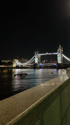 the tower bridge is lit up at night