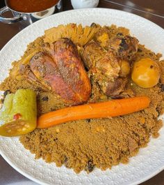 a white plate topped with meat and vegetables