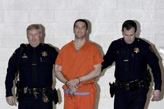 three men in orange jumpsuits standing next to each other with handcuffs on their hands