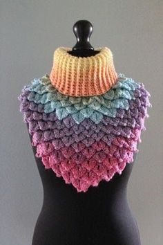 a black mannequin wearing a multicolored crocheted scarf