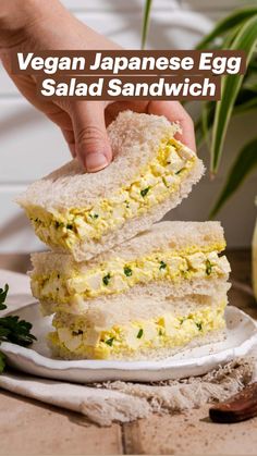 a person is holding two pieces of bread with eggs on it and sprinkled with parsley