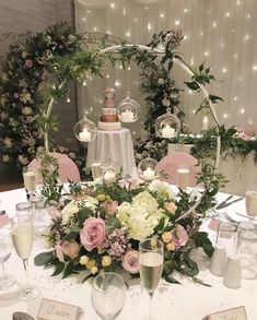 the table is set with flowers, candles and wine glasses for an elegant wedding reception