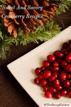 cranberries and pine cones on a white plate