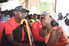 a man and woman sitting next to each other in front of a group of people