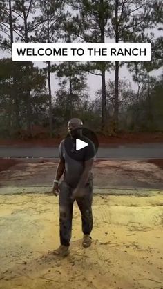 a man standing in the middle of a dirt field