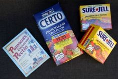 three boxes of cereal sitting on top of a black table next to two packets of fruit