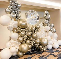 a table topped with lots of white and silver balloons