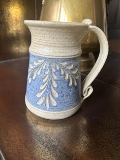 a blue and white vase sitting on top of a wooden table