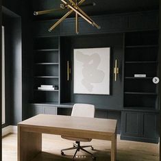 an office with black walls and wooden floors, white chairs and a desk in the center