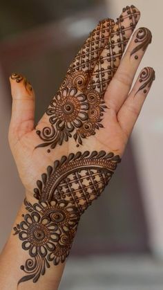 a woman's hand with henna tattoos on it