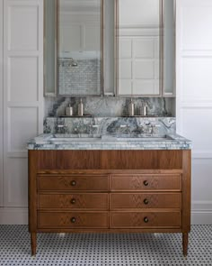 a bathroom vanity with two mirrors above it