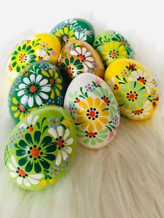 colorful painted eggs sitting on top of a white fur