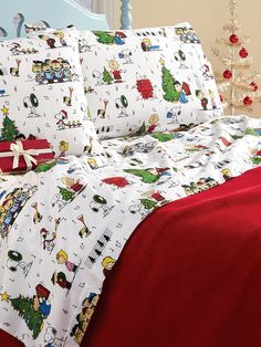 a bed covered in christmas themed sheets and pillows