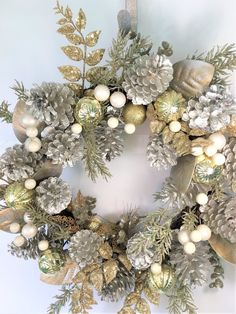 a christmas wreath with pine cones and ornaments