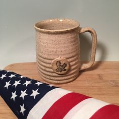 an american flag pillow next to a coffee mug