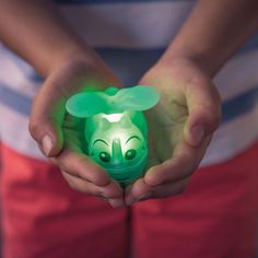 a person holding a green toy in their hands