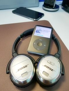 two mp3 players sitting on top of a table next to an ipod and cell phone