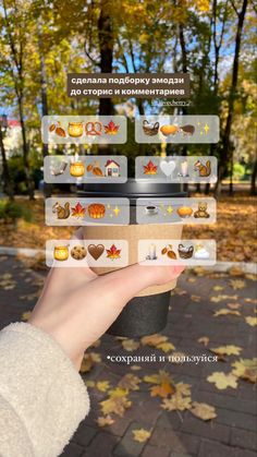 a person holding up a sticker in front of some autumn leaves and trees on the ground