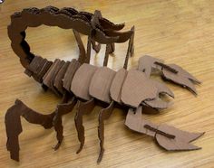 a crab made out of cardboard sitting on top of a wooden table