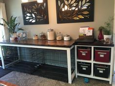 a dog kennel with some crates on the floor and two pictures hanging above it