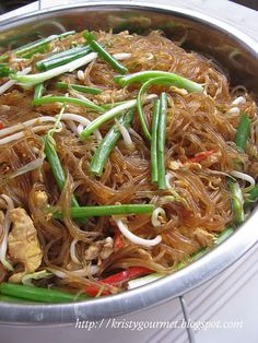 a pan filled with noodles and vegetables on top of a table