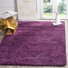 a purple area rug on the floor in front of a white door with a vase