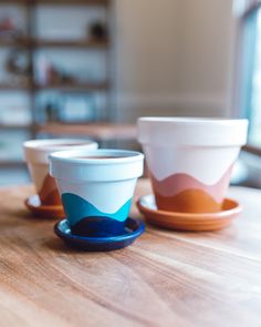 three cups sitting on top of a wooden table