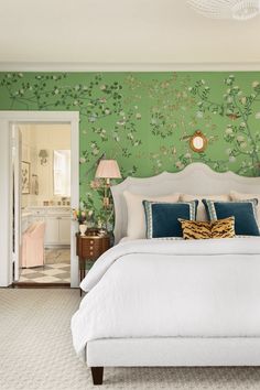 a bedroom with green wallpaper and white bed in the center, along with two lamps on either side of the bed