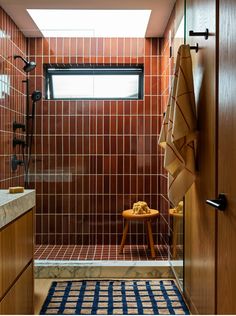 a bathroom with red tile and wooden cabinets