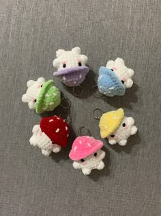 several small crocheted animals sitting on top of a gray cloth covered floor next to each other