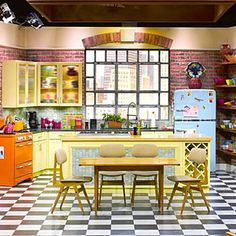 an image of a kitchen setting with yellow and red accents on the walls, checkered flooring