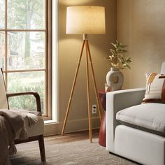 a living room scene with focus on the floor lamp and chair next to the window