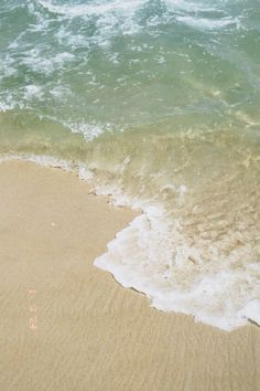 an ocean wave rolls in on the beach