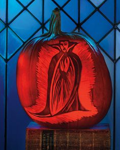 a red carved pumpkin sitting on top of a table