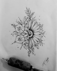 a drawing of a flower on paper with a pen next to it and an ink marker