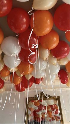 the ceiling is covered with balloons and streamers in white, orange, and red colors