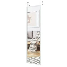 a large white mirror sitting on top of a wooden floor next to a wall mounted shelf