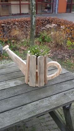 a wooden planter sitting on top of a picnic table next to a tree trunk