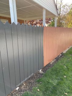 a wooden fence next to a house with grass